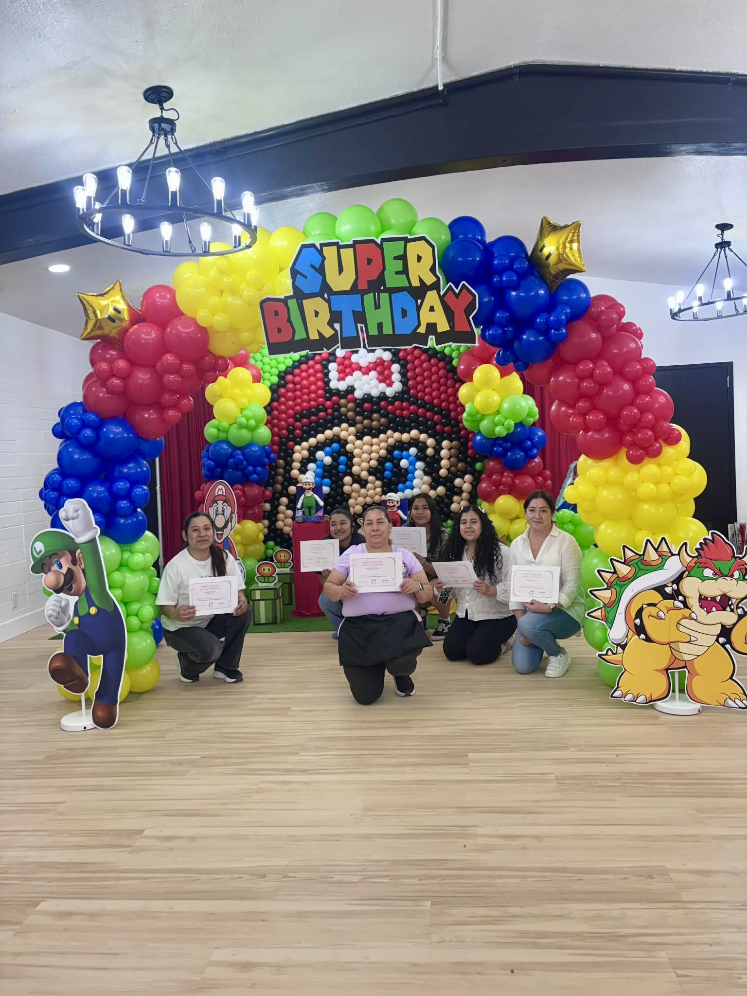 Balloon art class students holding their certificates